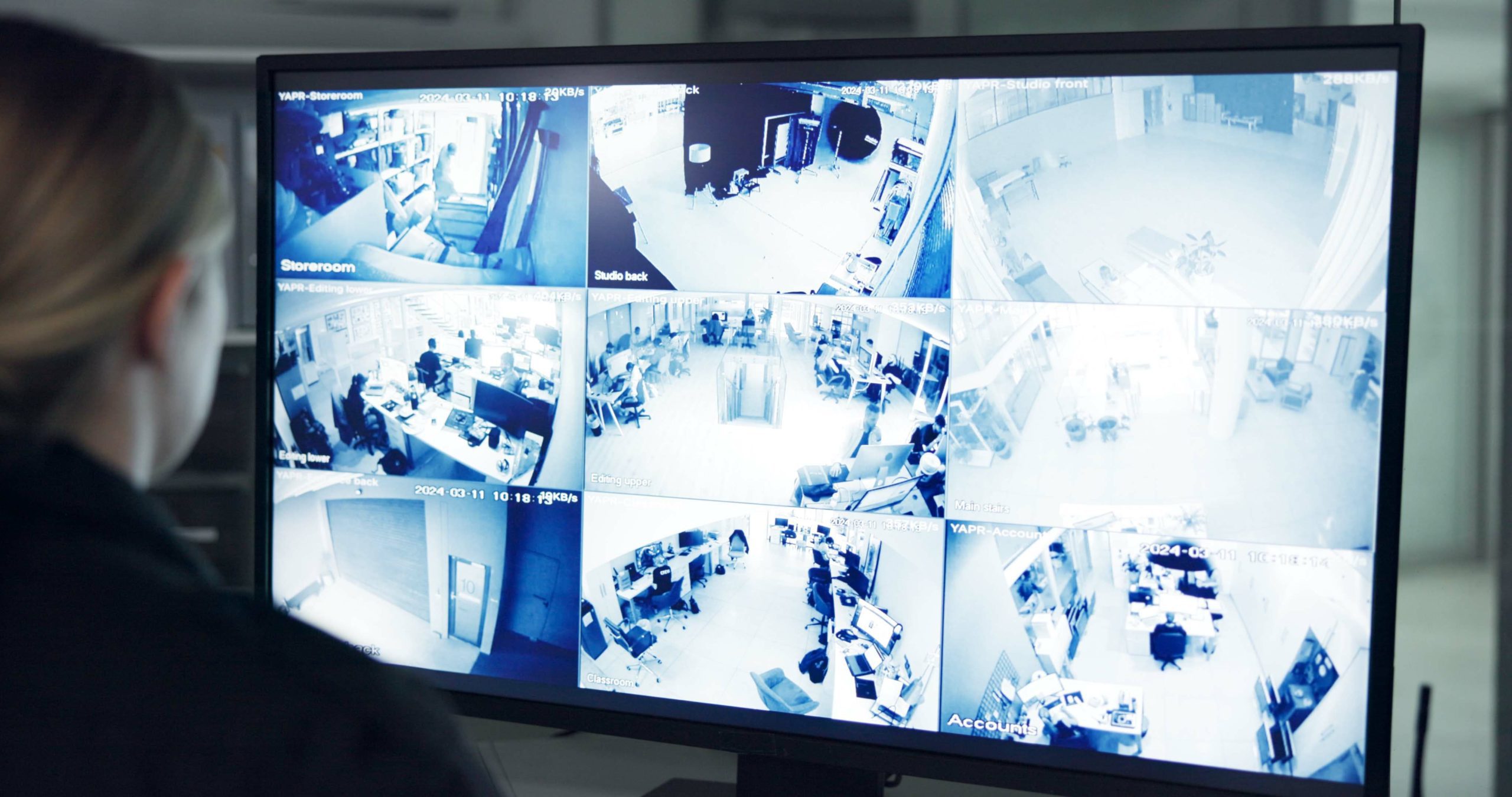 mulher inspecionando o sistema cftv no monitor